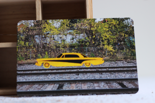 drawing of a yellow racing car on top of a train track picture.